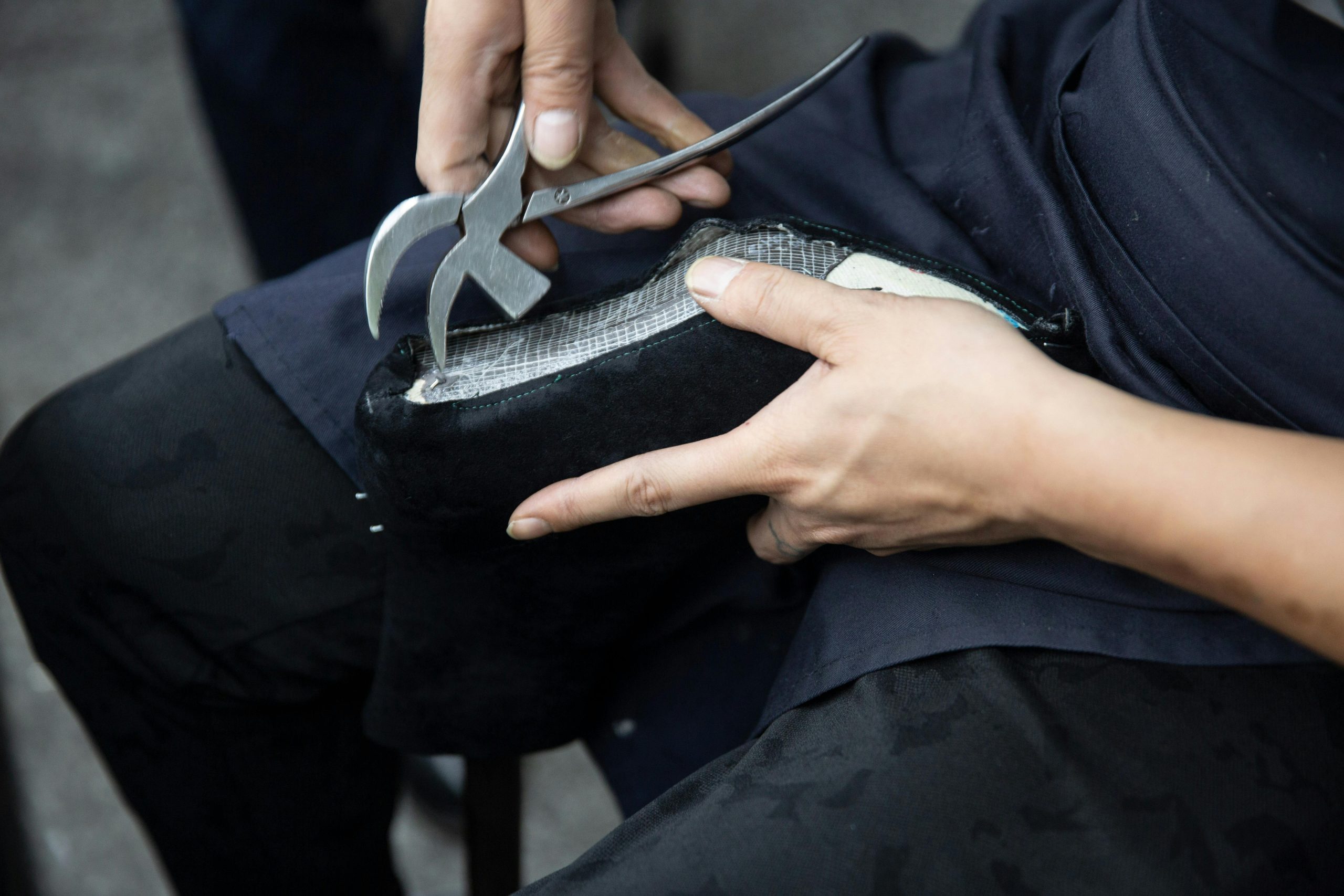 Home Close-up of a craftsman repairing a leather shoe with a cobbler's plier.